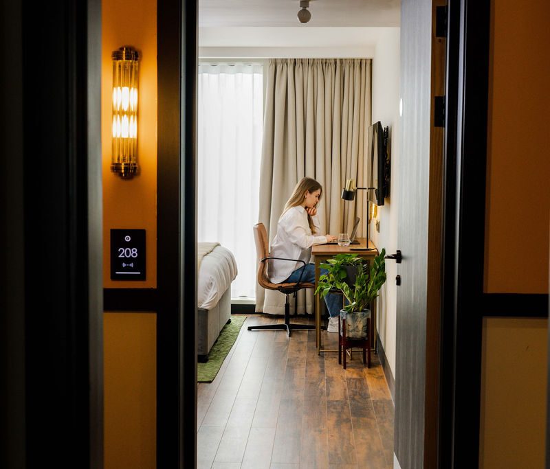 person working in bedroom in hotel suite room